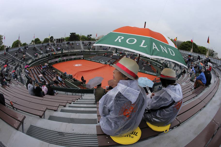 Spettatori infreddoliti sotto la pioggia al Roland Garros (Ap)